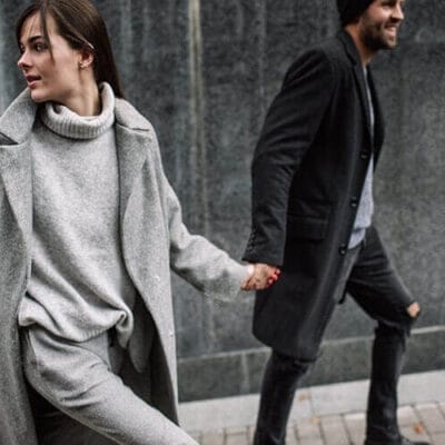 man and woman walking hand in hand, woman looking back